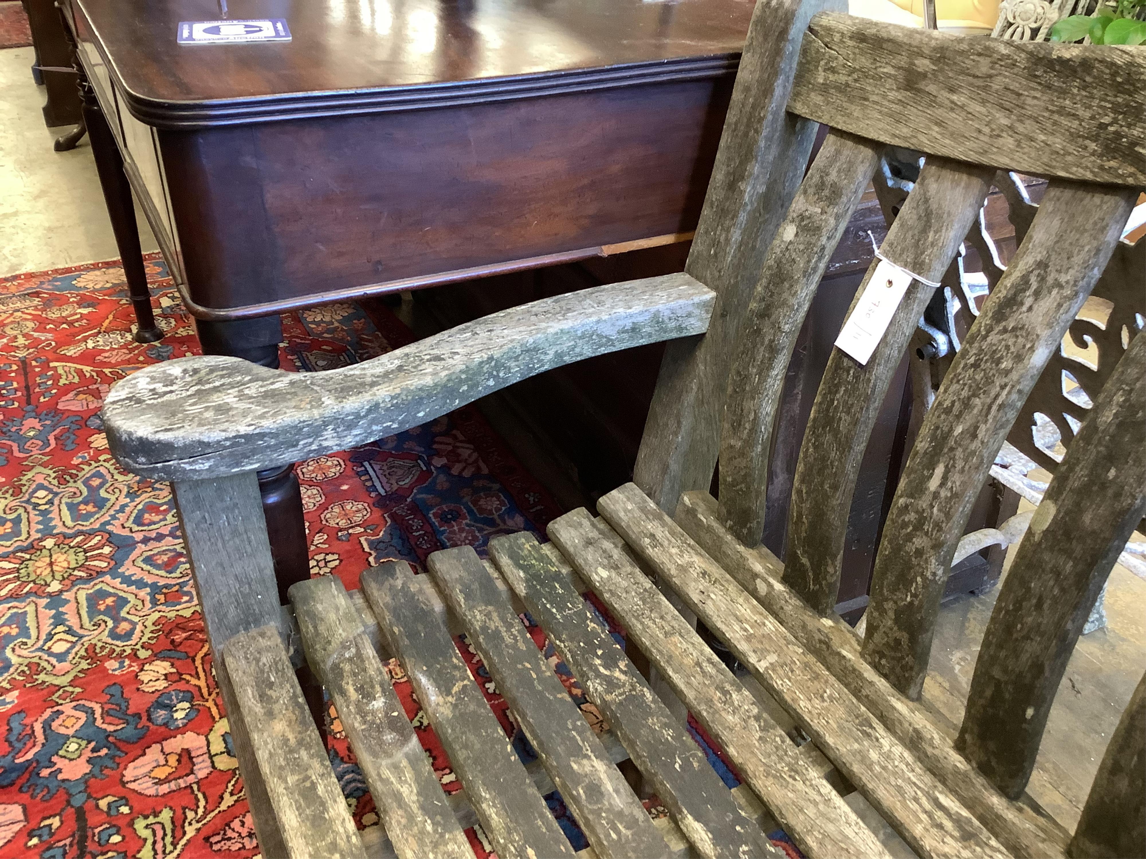 A weathered teak garden bench, length 155cm, depth 57cm, height 98cm
